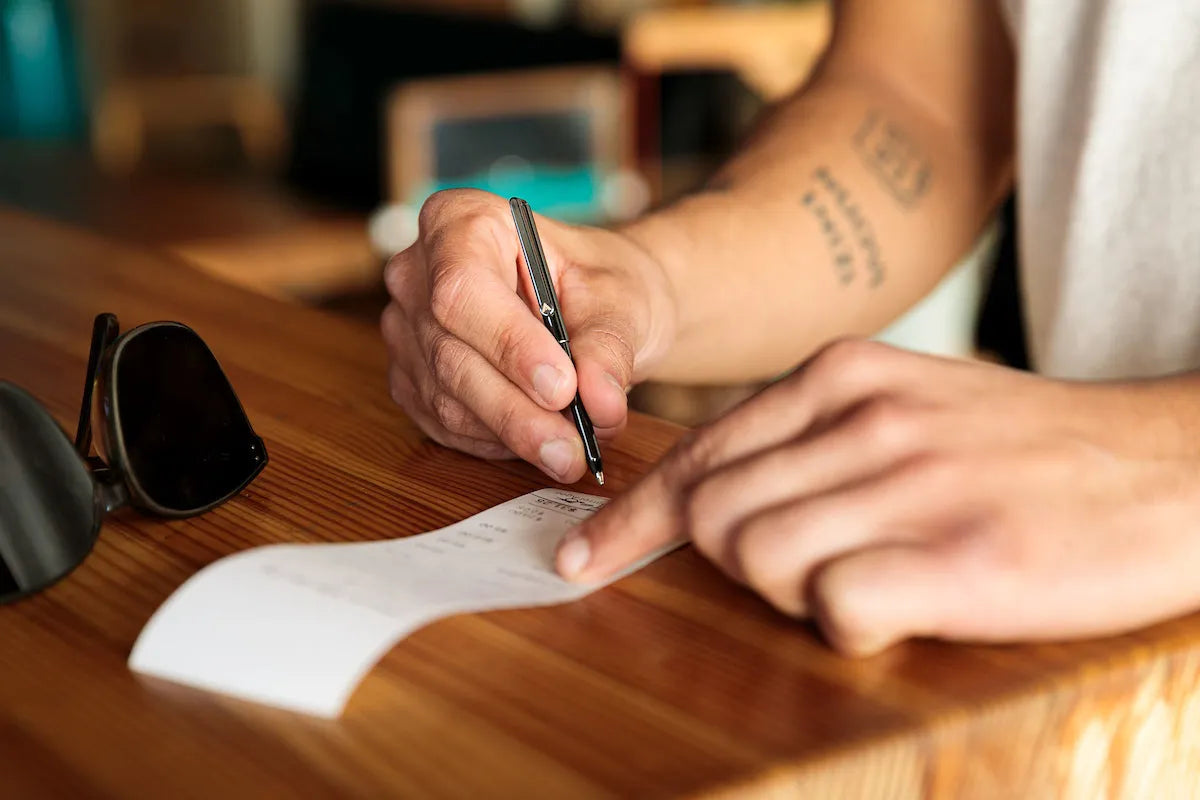 man writing with micro pen