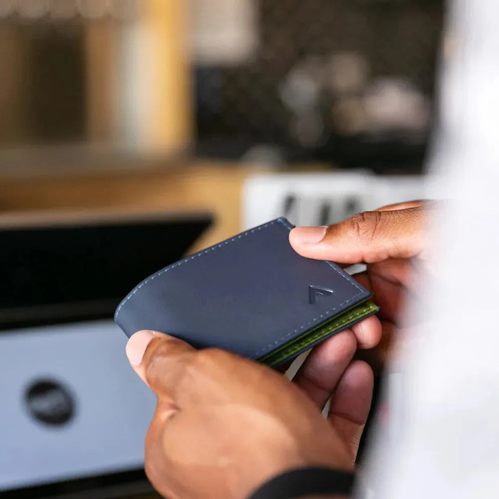 Hands lightly bending the Allett leather sports wallet to show how tactile it is. Allett Leather Sport Wallet- midnight-blue