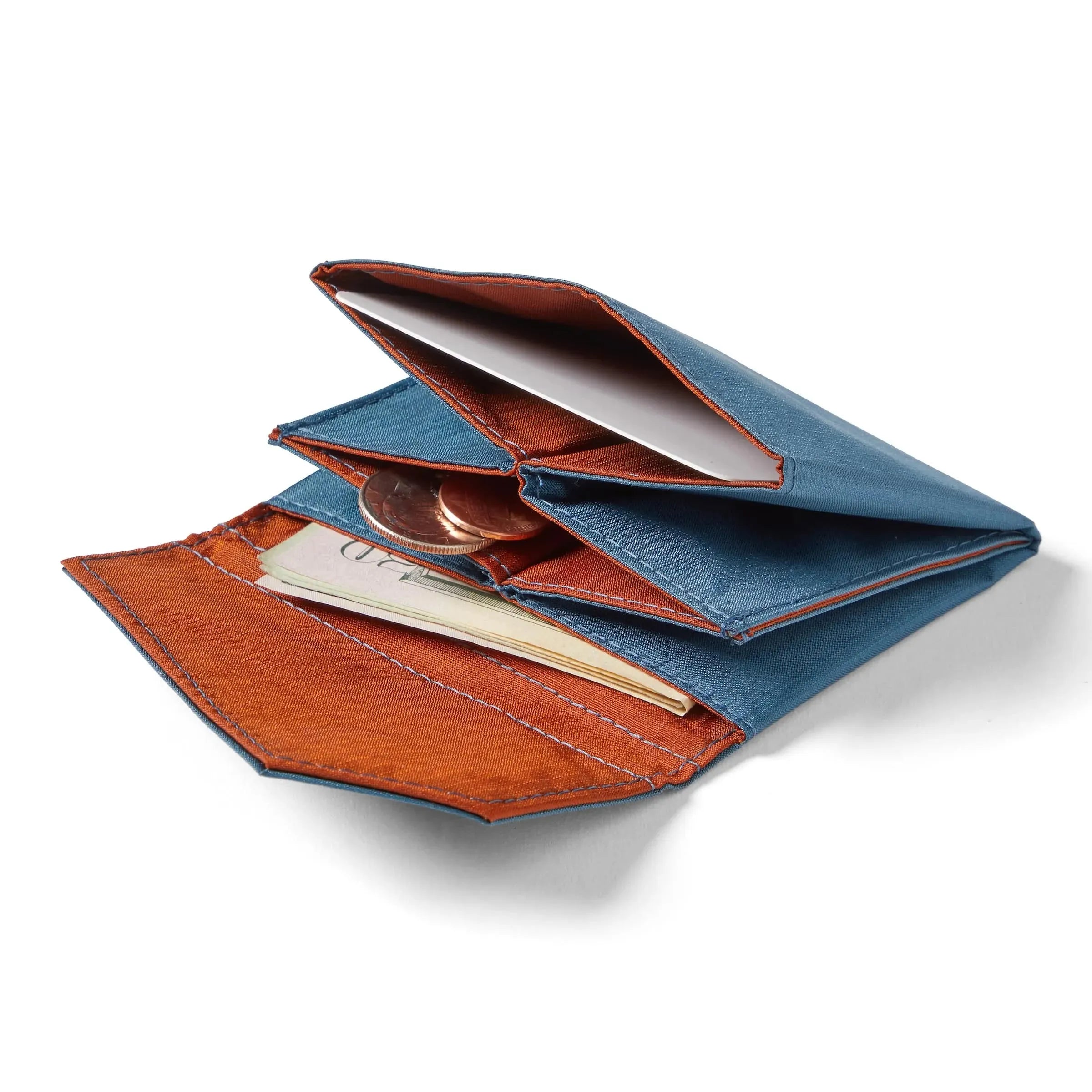Allett's premium indigo blue nylon accordion wallet with a slightly orange interior lying open on a white backdrop, with cash and coins slightly extending from the inner pockets. Allett Accordion Wallet in RFID Blocking Nylon  indigo-blue